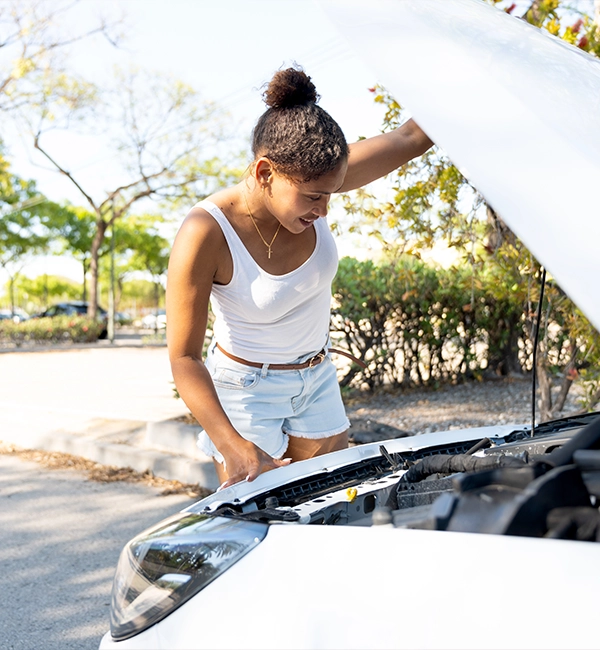 Woman checking car engine.