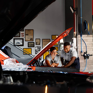 Two mechanics inspecting a car engine